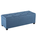 Blue rectangular upholstered storage ottoman with tufted lid on a white background